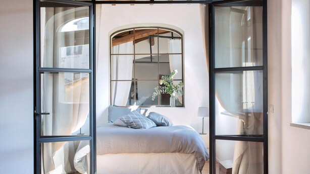 A bedroom with a large bed, a window with curtains, and a wooden floor. - Apartment The basket of the Angels, Florence amazing views (Firenze)