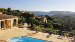 A pool area with lounge chairs, a view of the sea, and surrounding greenery. - VILLA 4 ROOMS 3 BATHROOMS WITH  HEATED POOL  500M SEA VIEW / MOUNTAIN (Zonza)