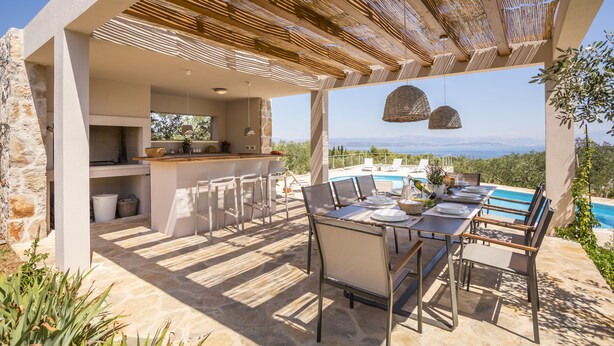 An outdoor dining area with a stone floor, a bar, and a view of the sea. - Hacienda NOA/secluded estate/practice golf/enjoy the view and great pool (Grohote, Island of Šolta)
