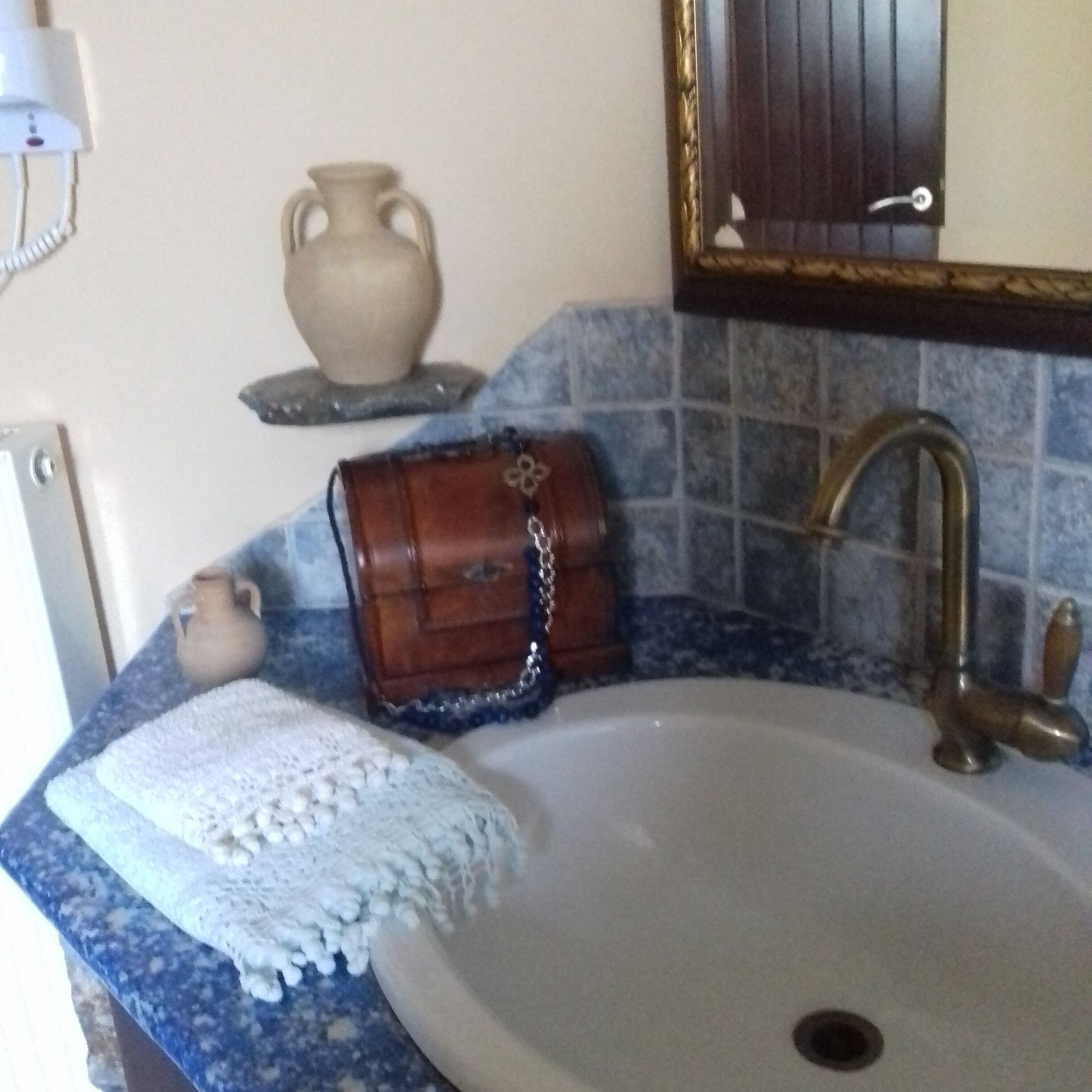 A bathroom with a sink, a mirror, and a towel on the counter.