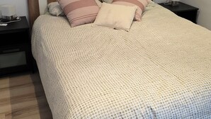 A neatly made bed with a patterned bedspread, a wooden headboard, and two bedside tables with a lamp and a tissue box. - HOLIDAY RENTAL HOUSE WITH GARDEN IN PALAMOS (Palamos)
