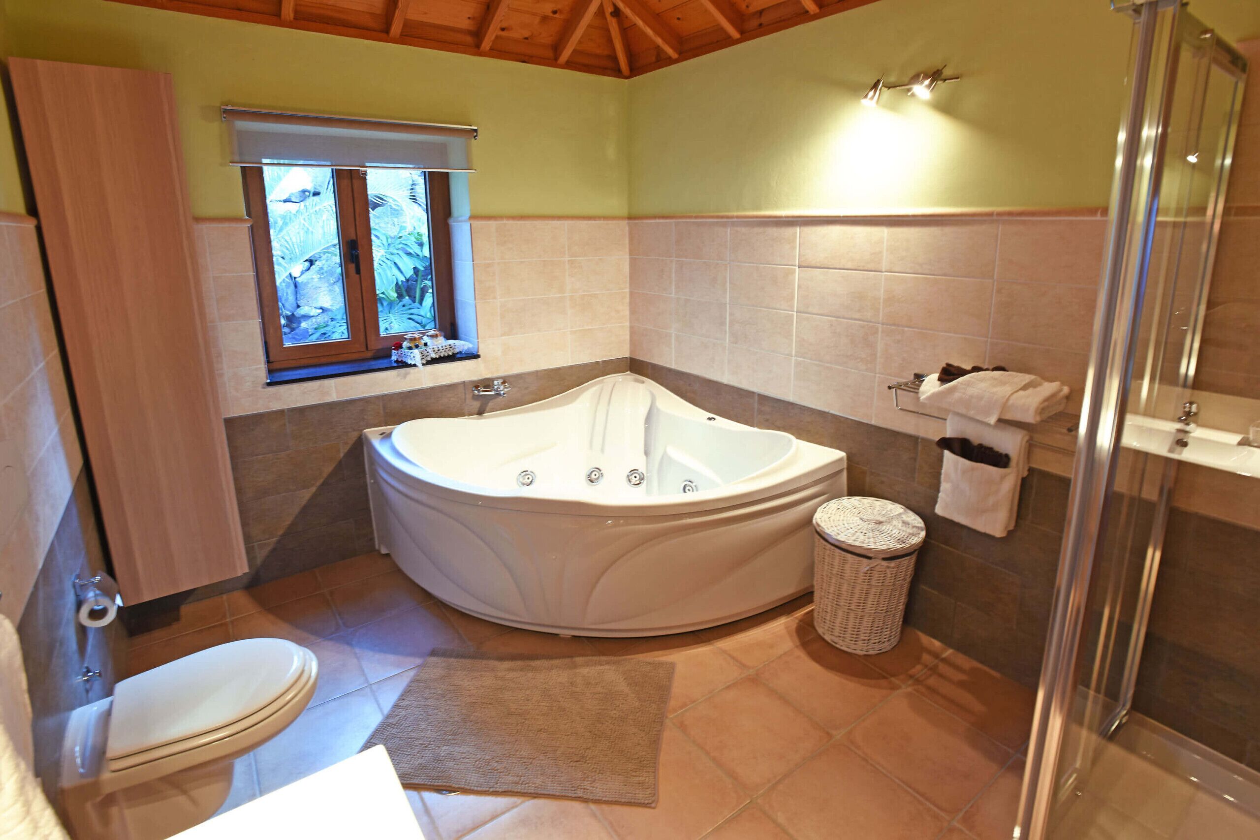Een badkamer met bad, toilet en douche.