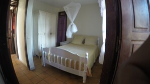 Una camera da letto con un letto, un armadio e una zanzariera.