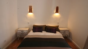 A bedroom with a bed, two nightstands, and wall-mounted lights. - Cosy Quiet Hideaway with Private Terrace, perfect location old town Tarifa (Tarifa)
