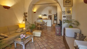 A cozy living room with a sofa, coffee table, and a dining area with chairs and a table. - House with character (Feliceto)