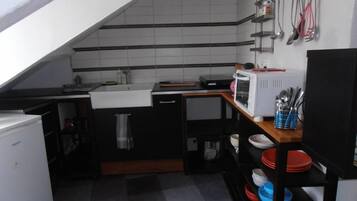 Een koelkast, een oven, een kookplaat, een koffiezetapparaat/waterkoker