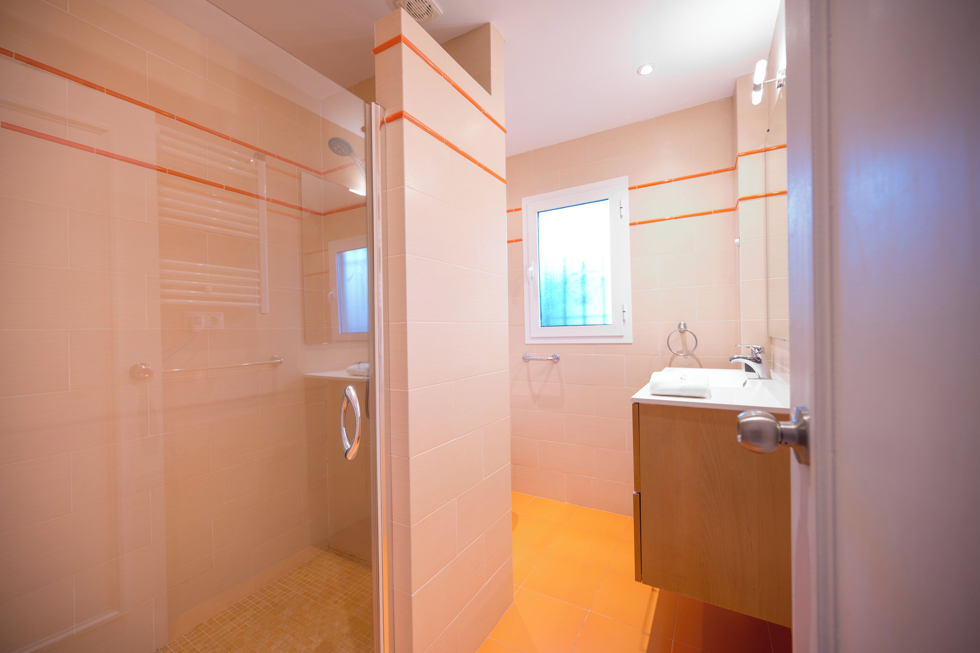 Une salle de bain avec une douche, un lavabo et un miroir.