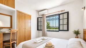 A bedroom with a bed, a desk, a chair, a wardrobe, and a window with a view. - Algarve, Casa Julio, Albufeira Town, Beside The Strip (Albufeira)
