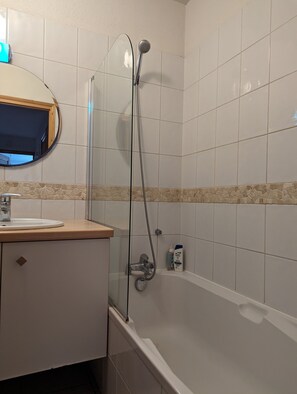 Banheira, secador de cabelo, toalhas de banho 