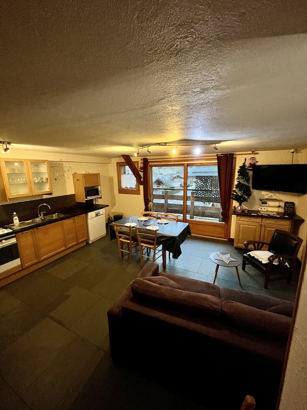 A compact living space with a kitchen, dining area, and a sofa. - Apartment Narcisse*** 3 bedrooms 5 persons in Multipass private house (Morzine)