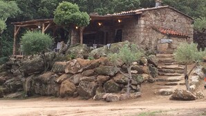 A rustic stone house with a tiled roof, surrounded by large rocks and trees. - Luxury mini villa with garden & swimming pool in residence, 800m from the beach (Zonza)