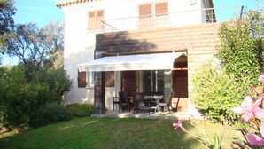A two-story house with a covered patio area featuring a table and chairs. - Luxury mini villa with garden & swimming pool in residence, 800m from the beach (Zonza)