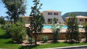 A two-story building with a swimming pool, surrounded by greenery and hills in the background. - Luxury mini villa with garden & swimming pool in residence, 800m from the beach (Zonza)