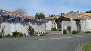 A building with a concrete facade, a tiled roof, and a small entrance.