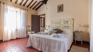 Une chambre à coucher avec un lit, une table de chevet, une lampe et un tableau accroché au mur.