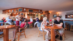 A bar area with wooden furniture and a television screen. - Club Oceano 2 bedroom Apts. (Puerto del Carmen)