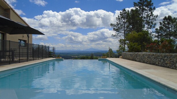 A swimming pool with a view of mountains and trees. - Newly built, secluded villa with a pool—sleeps 8 to 12—sauna—air conditioning (Saint-Julien-De-Peyrolas)