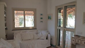 A room with a white sofa, a patterned floor, a window, and a small cabinet. - Villa in Maratea   Walking Distance From The Beach  CIN-IT076044C203105001 (Acquafredda,  Maratea)