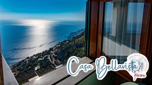 A view from a window overlooking a coastal town with a sign reading "Casa Bella Vista". - CASA BELLAVISTA ( “Bellavista” holiday home ) ……Where hospitality is at home (Furore)
