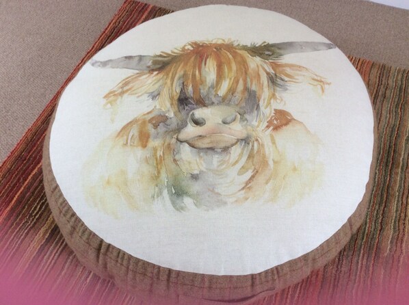 A pillow with a painting of a yak.