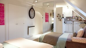 A bedroom with two beds, a kitchenette, and a bathroom. - Studio With a Nice View of Paris - Luxury Building in the Heart of the Marais (Paris)