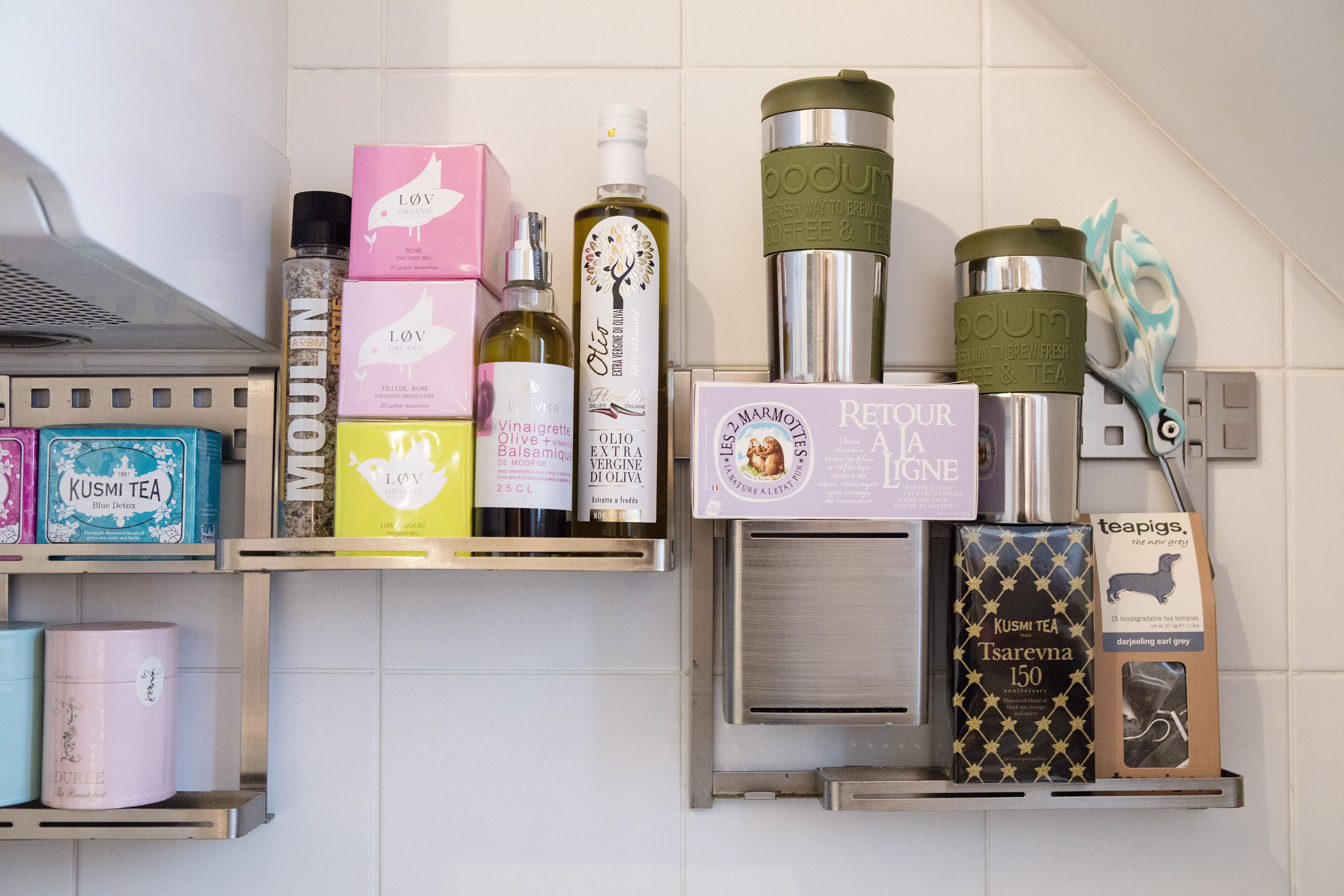 Une étagère de cuisine contenant divers produits liés au thé et des ustensiles de cuisine.