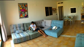A living room with a sofa, a dining table, and a kitchen area. - Altea - family apartment !! Close to the sea. (Altea)