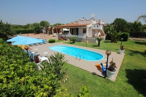 A swimming pool with a tiled deck, surrounded by lush greenery and a building with a tiled roof. - HOMESICILY - Holiday House with private pool for a total relaxing.... (Floridia)