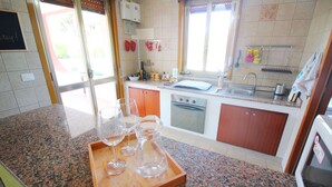 Una cocina con encimeras de granito, horno empotrado y un lavamanos.