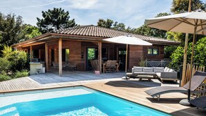 A poolside area with a wooden deck, a pool, and outdoor furniture. - House / Villa - Porto vecchio (Porto-Vecchio)
