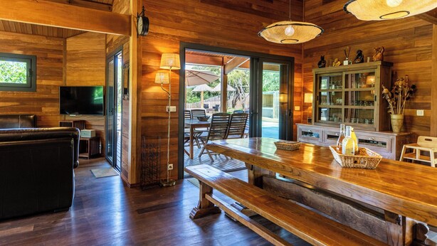 A wooden interior with a dining area, a sofa, and a television. - House / Villa - Porto vecchio (Porto-Vecchio)