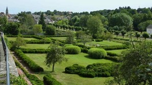 Un jardin bien entretenu, avec des haies soigneusement taillées et une grande variété d’arbres.