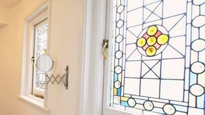 A door with a stained glass window featuring geometric patterns and a circular design in the center.