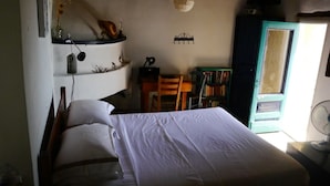 Une chambre à coucher avec un lit, une chaise, un bureau et une bibliothèque.