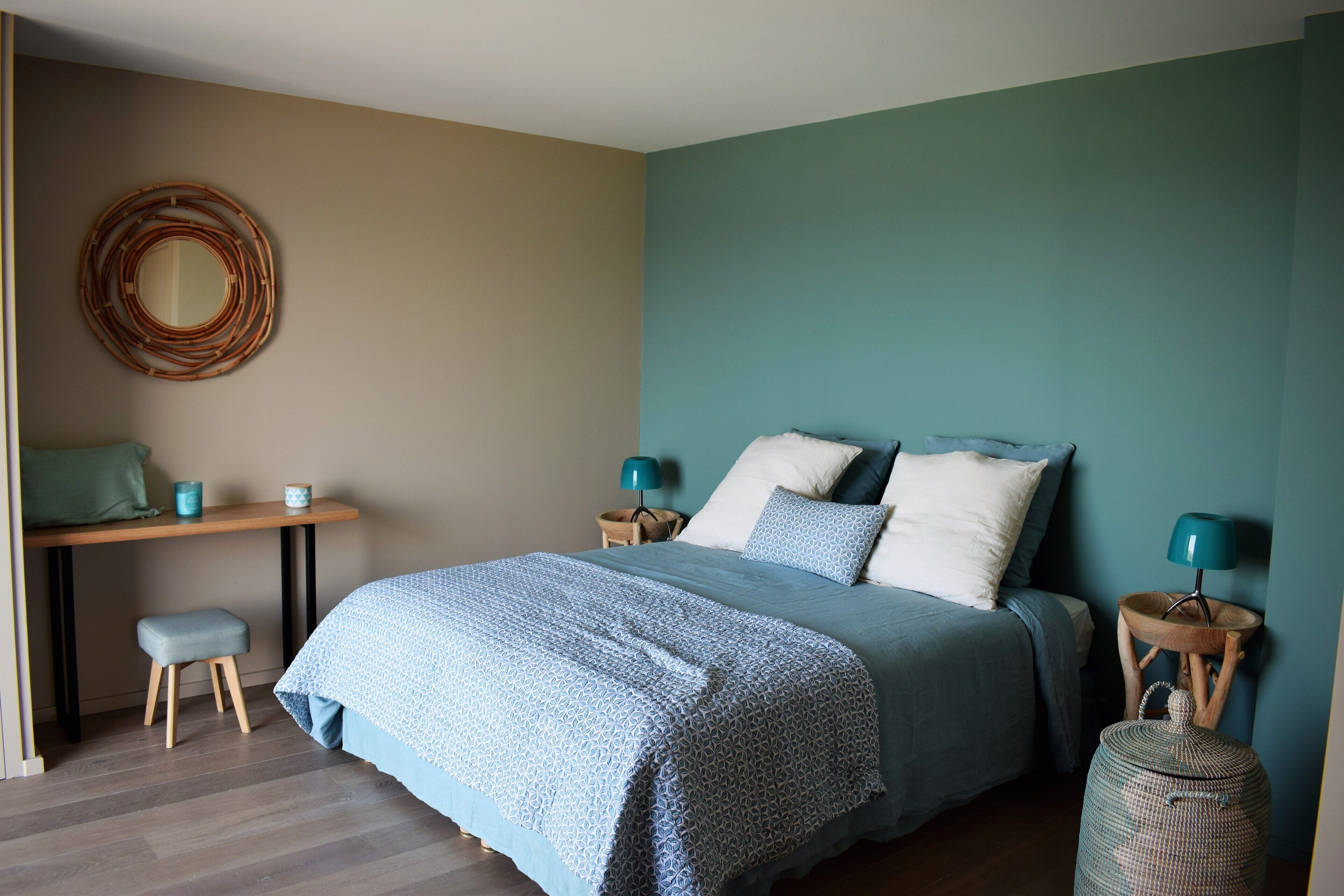A bedroom with a bed, bedside tables, a desk, and a chair.
