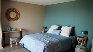 A bedroom with a bed, bedside tables, a desk, and a chair.