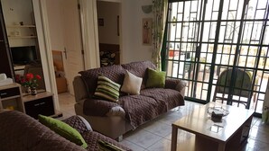 A living room with two sofas, a coffee table, and a TV on a stand.