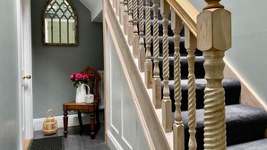 A staircase with a wooden balustrade and a decorative mirror on the wall.