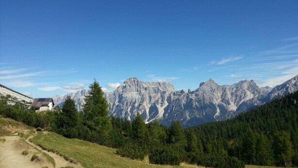 A mountain landscape with a house and a path. - Sagui apartment in the heart of the Dolomites CIN 025069C2H8ECUEQQ  (Zoppe' di Cadore (Belluno))