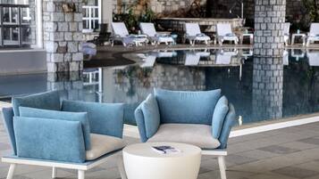 A poolside area with lounge chairs and a white table.