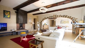 A spacious living room with a white sofa, red rug, and a stone archway. - Luxury villa near Saint Tropez, Swimming Pool, Big Garden Super sea view, 220m2 (Cavalaire-Sur-Mer)