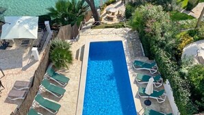 A rectangular swimming pool with lounge chairs and a table on a patio area. - Villa Acuarela - 5 beds, 4 bath. Front line villa in Cala d'or. (Cala d´or)