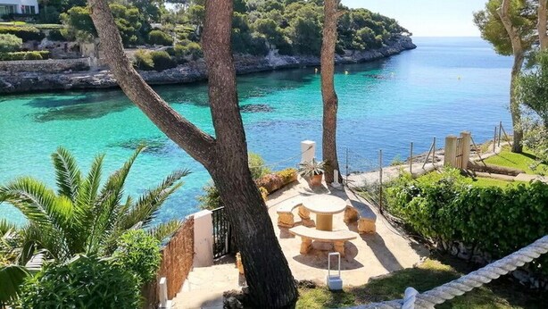 A coastal property with a patio area, outdoor seating, and a view of the sea and a rocky island. - Villa Acuarela - 5 beds, 4 bath. Front line villa in Cala d'or. (Cala d´or)