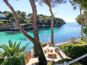 A coastal property with a patio area, outdoor seating, and a view of the sea and a rocky island. - Villa Acuarela - 5 beds, 4 bath. Front line villa in Cala d'or. (Cala d´or)