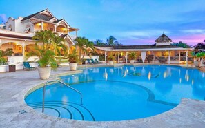 A resort with a large swimming pool, lounge chairs, and a covered area with a view of the pool. - Poolside apartment (2 bed) in exclusive Sugar Hill Resort (Holetown)