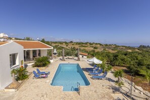 A swimming pool with lounge chairs and a view of the landscape.