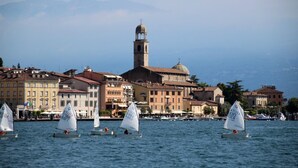 A waterfront scene with sailboats, historic buildings, and a prominent tower. - Your country Villa with a amazing view, private garden and private pool! (salò (bs))