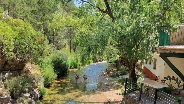 A river flowing through a forested area with a building on the right. - Rural house Nº13 Molino Jaraiz for 8 people (Yeste)