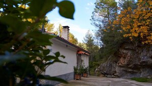 A rustic building with a tiled roof, surrounded by trees and a rocky cliff. - Rural house Nº13 Molino Jaraiz for 8 people (Yeste)