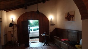 Ein gemütliches Interieur mit einem hölzernen Bogen, der nach einem Auto führt, einer Bank, einem Tisch mit Gegenständen und einer Chandelieber.